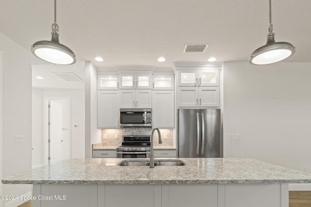 kitchen with white cabinets, pendant lighting, stainless steel appliances, and sink