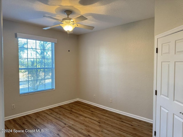 unfurnished room featuring dark hardwood / wood-style floors and ceiling fan