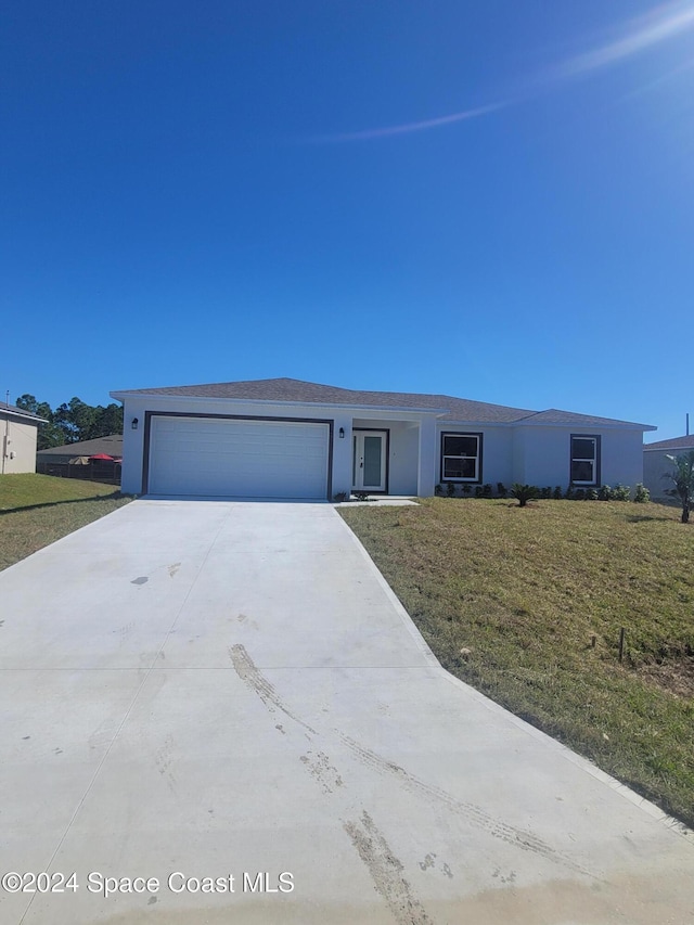 view of front of home featuring a garage and a front lawn