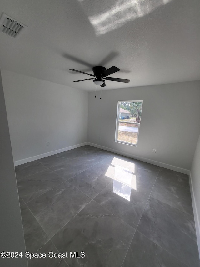 empty room featuring a textured ceiling and ceiling fan