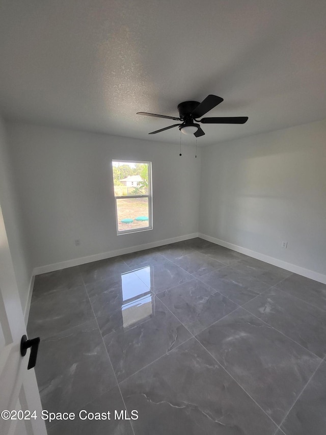 empty room featuring ceiling fan and a textured ceiling