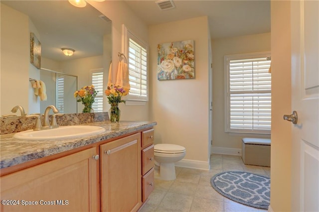 bathroom with tile patterned flooring, vanity, toilet, and an enclosed shower