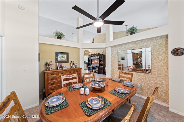 carpeted dining space featuring ceiling fan and high vaulted ceiling