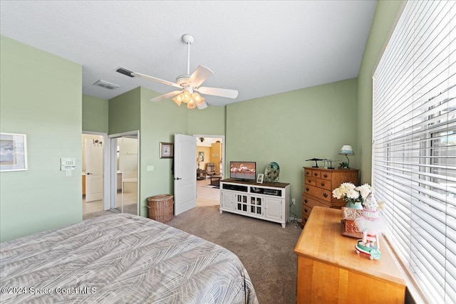 bedroom with ceiling fan, carpet floors, and a textured ceiling