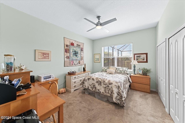 carpeted bedroom featuring ceiling fan and a textured ceiling