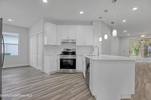 kitchen with white cabinetry, sink, kitchen peninsula, decorative light fixtures, and appliances with stainless steel finishes