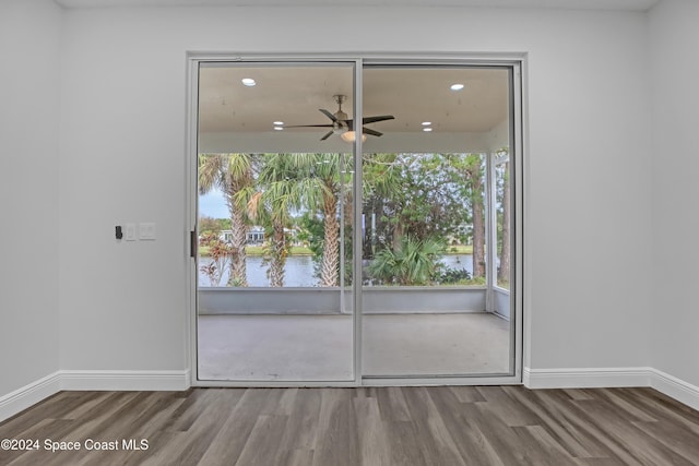 spare room with wood-type flooring, a water view, and ceiling fan