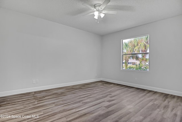 empty room featuring a textured ceiling, light hardwood / wood-style floors, and ceiling fan