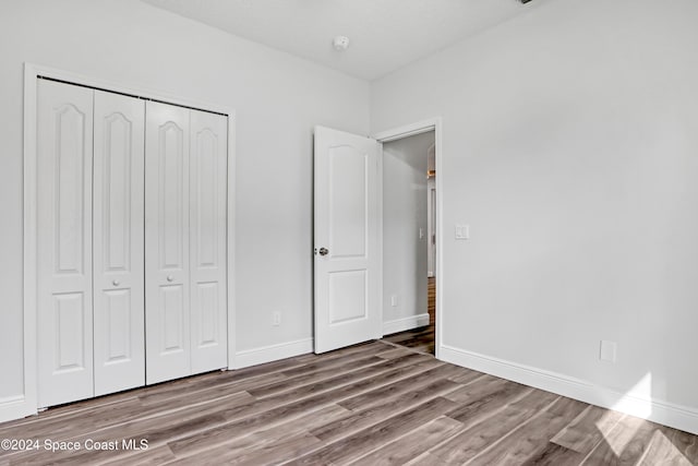 unfurnished bedroom featuring a closet and light hardwood / wood-style floors