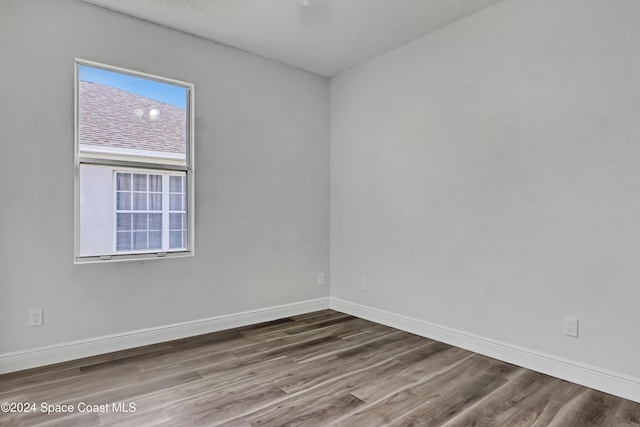 unfurnished room featuring wood-type flooring and a textured ceiling