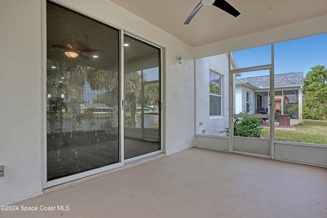 unfurnished sunroom featuring ceiling fan