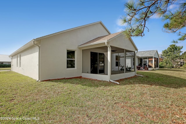 rear view of house featuring a sunroom and a yard