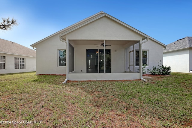 back of property with ceiling fan and a lawn