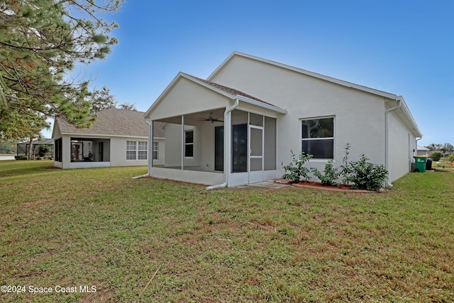 back of property featuring a sunroom and a lawn