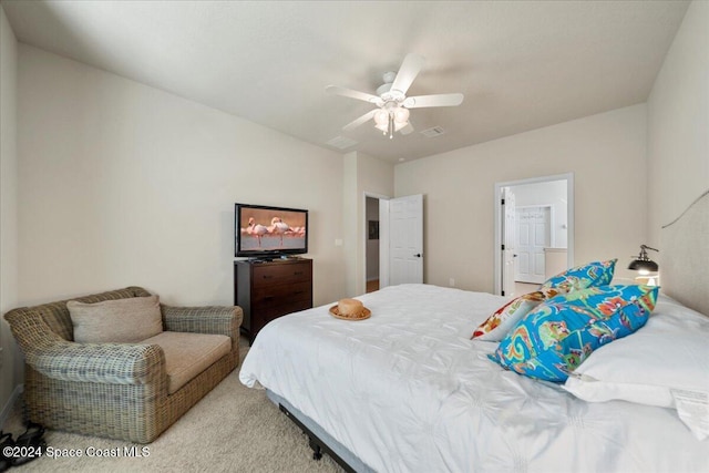 bedroom featuring ceiling fan, light carpet, and ensuite bath