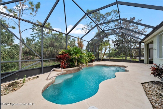 view of pool with glass enclosure and a patio area