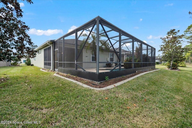 back of property featuring a yard and glass enclosure