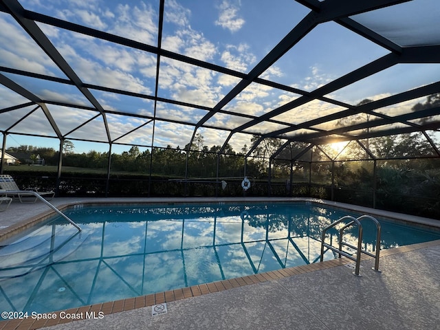 view of swimming pool featuring a patio and a lanai