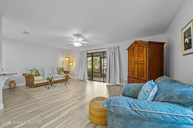 living room with ceiling fan and light hardwood / wood-style flooring