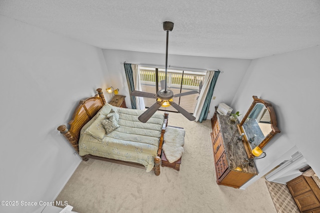 sitting room featuring ceiling fan, light colored carpet, and a textured ceiling