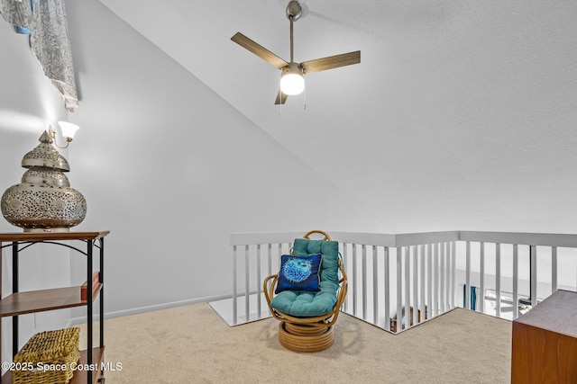 living area featuring carpet, vaulted ceiling, and ceiling fan