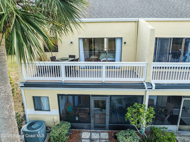 rear view of house with a sunroom and a balcony