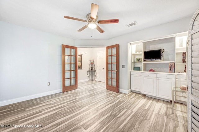 unfurnished living room with ceiling fan, french doors, and light hardwood / wood-style floors