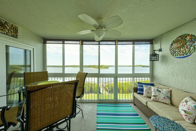 sunroom / solarium with a water view and ceiling fan