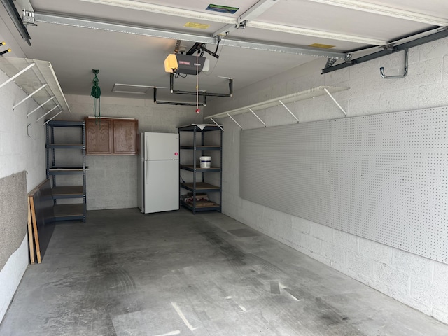 garage with white fridge and a garage door opener