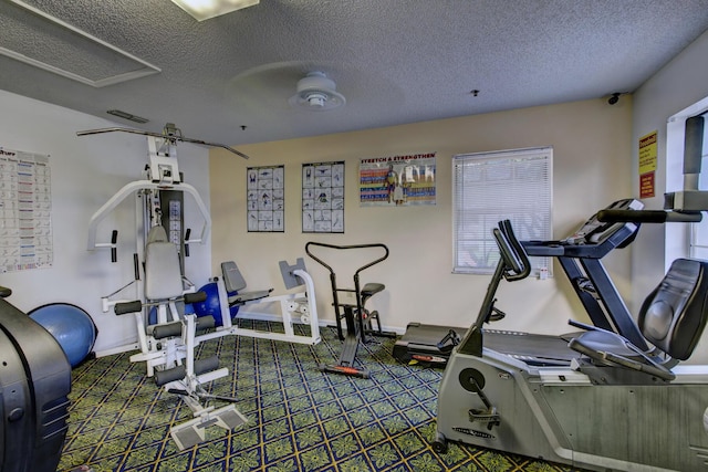 exercise room with carpet floors and a textured ceiling