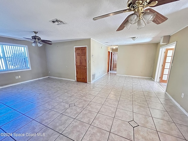 tiled spare room featuring ceiling fan and a textured ceiling