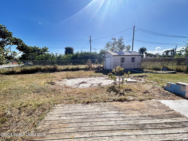 view of yard with an outbuilding, a garage, and a wooden deck