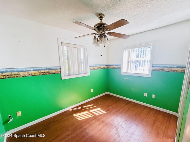 unfurnished room with hardwood / wood-style floors, a textured ceiling, and ceiling fan