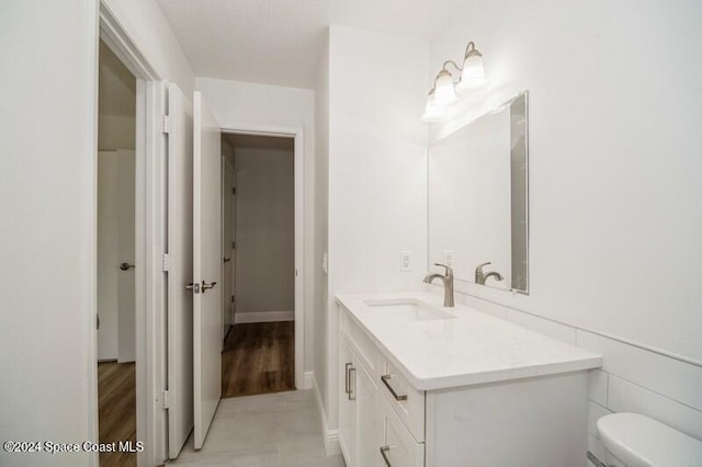 bathroom featuring hardwood / wood-style floors, vanity, and toilet