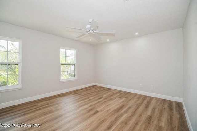 empty room with ceiling fan and light hardwood / wood-style floors