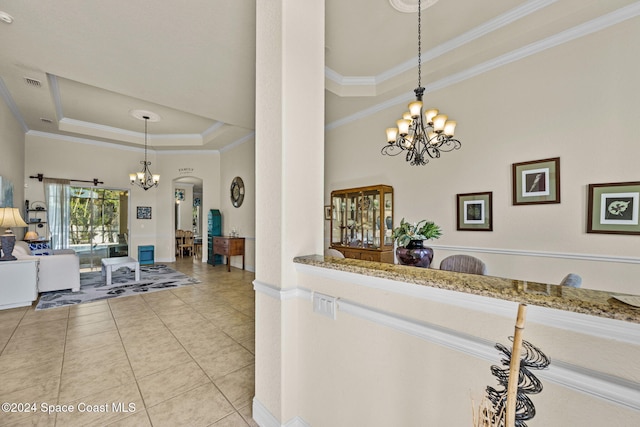 kitchen featuring a raised ceiling, crown molding, pendant lighting, and an inviting chandelier