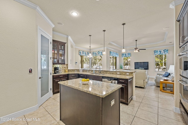 kitchen with dark brown cabinetry, a center island, and ceiling fan with notable chandelier