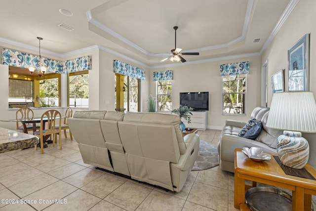 living room featuring a tray ceiling, a wealth of natural light, crown molding, and ceiling fan with notable chandelier