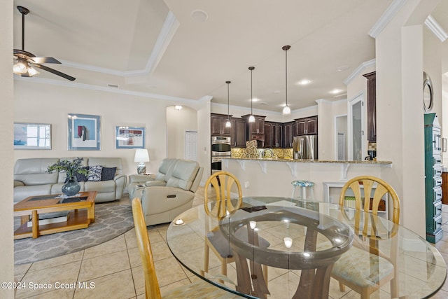 tiled dining area with ceiling fan, ornamental molding, and sink