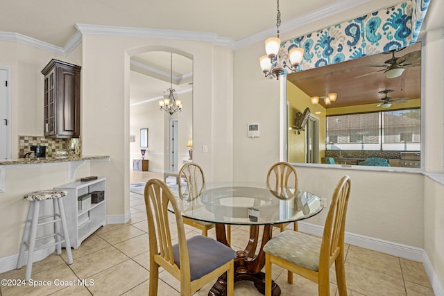 tiled dining area with ceiling fan with notable chandelier and crown molding