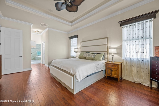 bedroom with dark hardwood / wood-style flooring, connected bathroom, ceiling fan, and ornamental molding