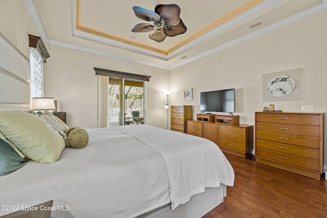 bedroom with ceiling fan, a raised ceiling, dark hardwood / wood-style floors, crown molding, and access to outside