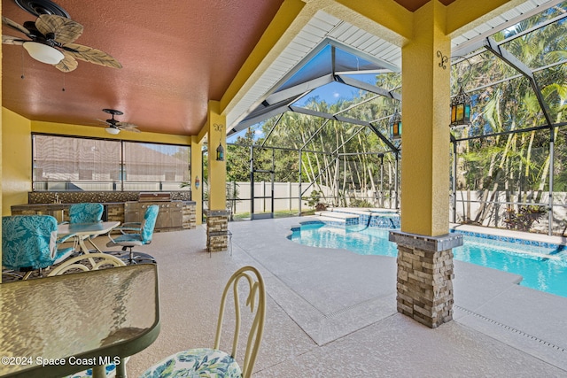 view of swimming pool with grilling area, exterior bar, ceiling fan, a lanai, and a patio area