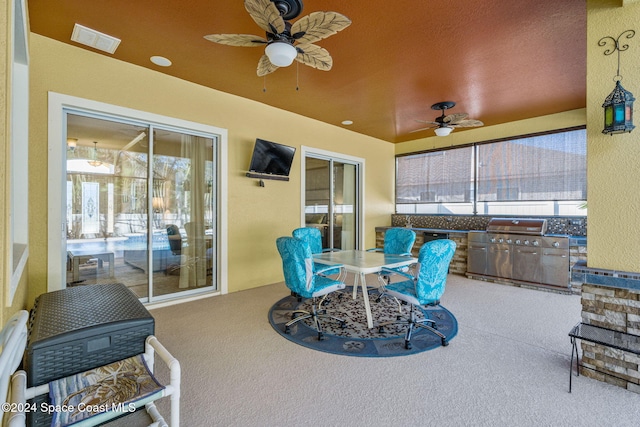 view of patio / terrace featuring area for grilling, ceiling fan, and exterior kitchen