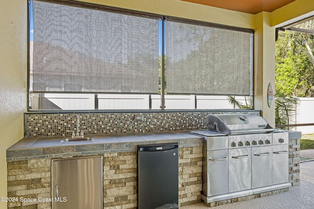 view of patio / terrace with area for grilling, a grill, and sink