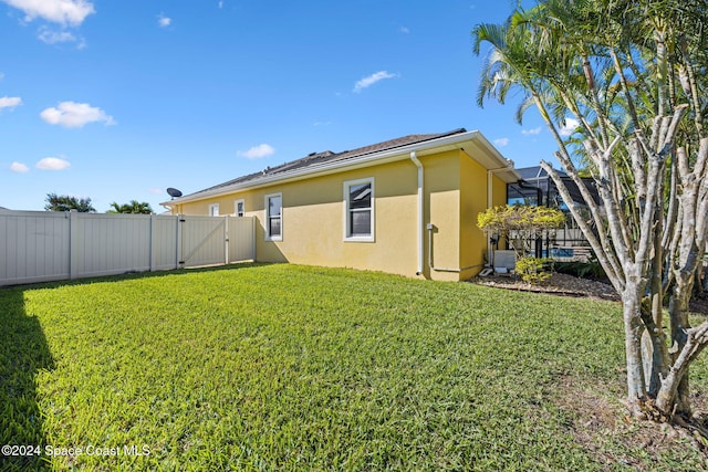 rear view of property featuring a lawn