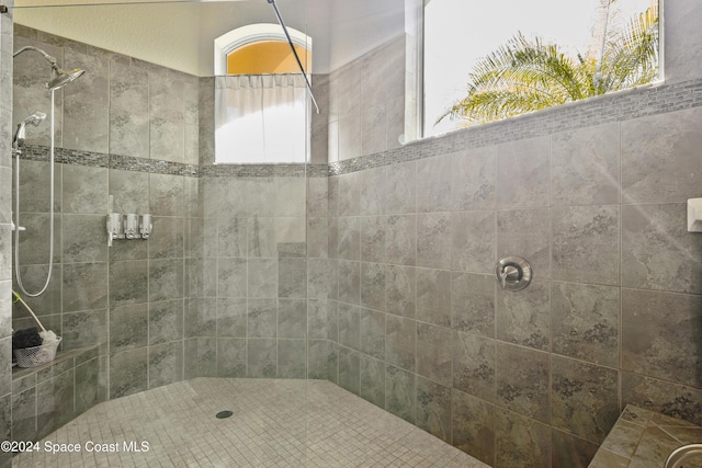 bathroom with tiled shower and a wealth of natural light