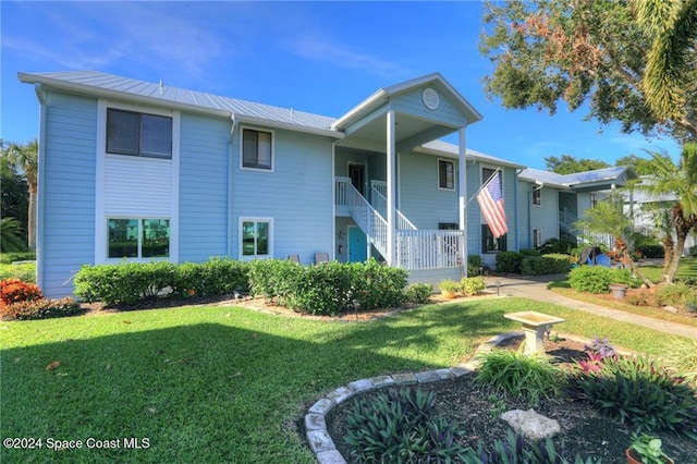 back of property with a porch and a yard