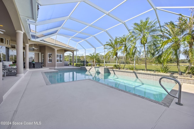 view of pool with glass enclosure, ceiling fan, and a patio