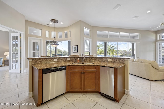 kitchen with pendant lighting, stone counters, sink, stainless steel dishwasher, and light tile patterned floors